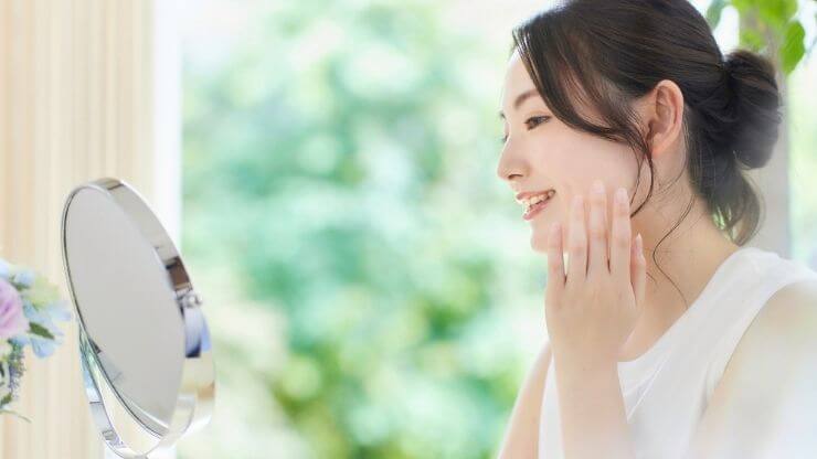 鏡を見て微笑む女性の写真