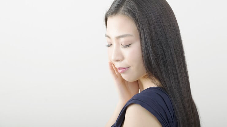 目を閉じて微笑む女性の画像