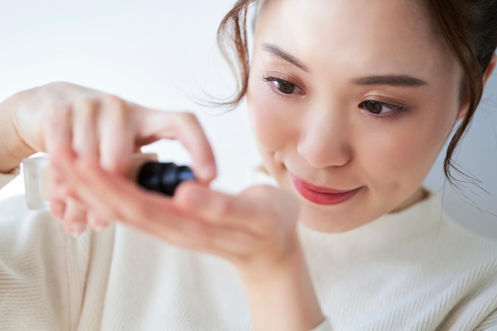 リキッドファンデーションを手に出している女性の画像