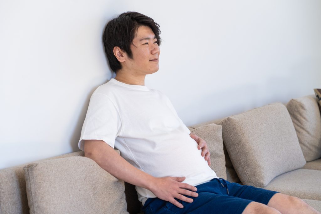お腹まわりを触る中年男性