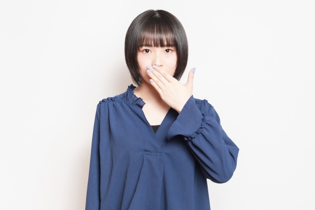 口を抑える若い女性