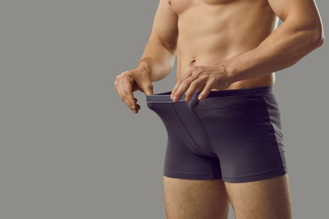 ボクサーパンツのウエストゴムを広げている男性