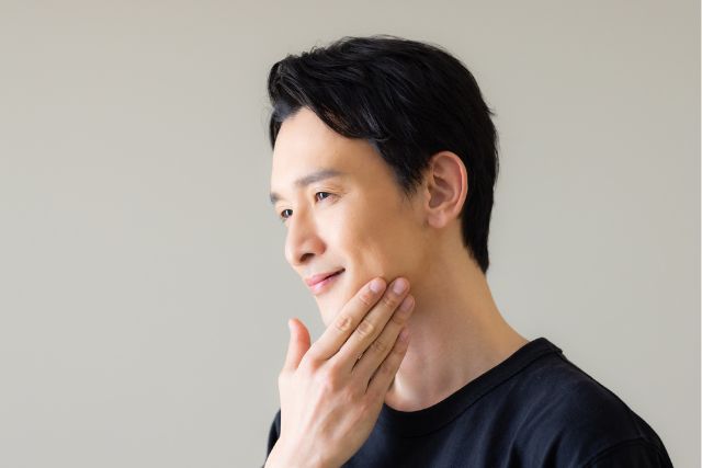 顎に手を添えて微笑む男性
