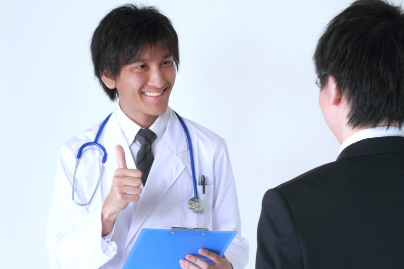 笑顔で診断結果を話す医者