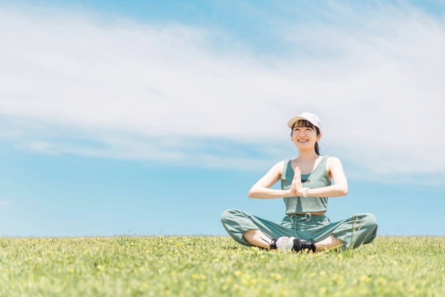 青空の下でヨガをする女性